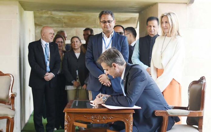Prime Minister of Hellenic Republic (Greece), Mr. Kyriakos Mitsotakis writing his remarks in the visitor book after visiting the Samadhi of Mahatma Gandhi at Rajghat, in Delhi on Wednesday.