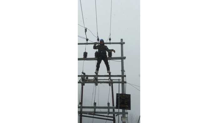 Frontline worker of KPDCL during restoration work amidst heavy snow.