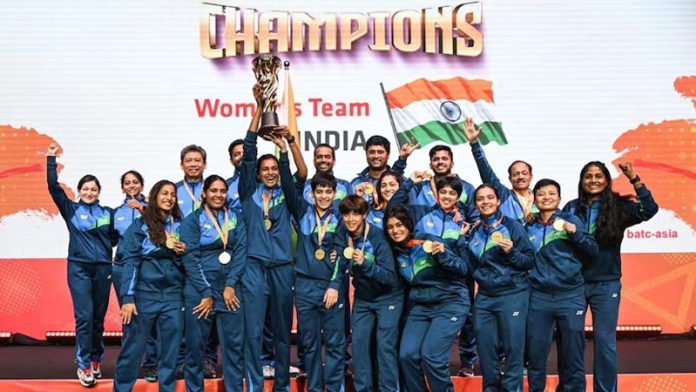 Indian women Badminton team posing with trophy.