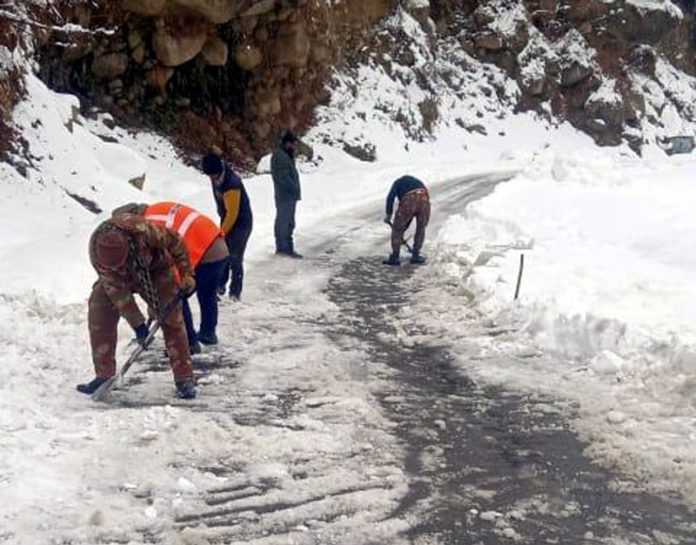 BRO officials in action to clear the snow from Ishtiyari road in Kishtwar on Wednesday.