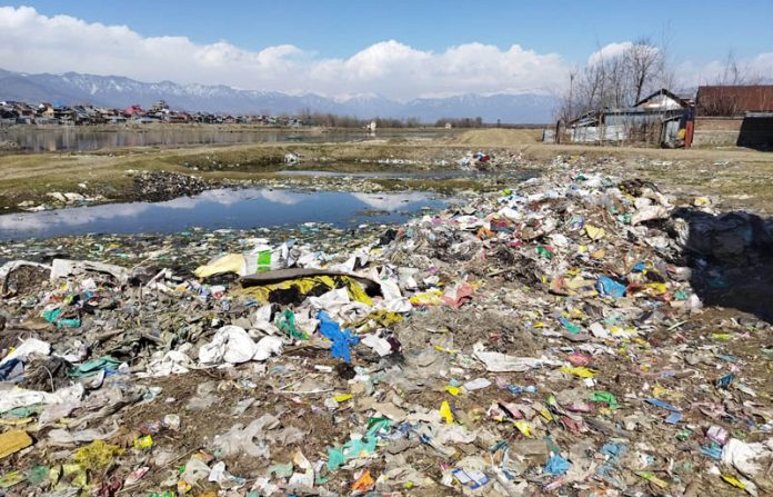 Waste left unattended on the banks of Jhelum near Sher Colony in Sopore. -Excelsior/Aabid Nabi