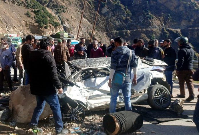 Rescue workers and others surround the mingled remains of a car which met with accident at Kishtwar. -Excelsior/Tilak Raj