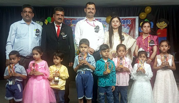 Kindergarten students posing with school management.