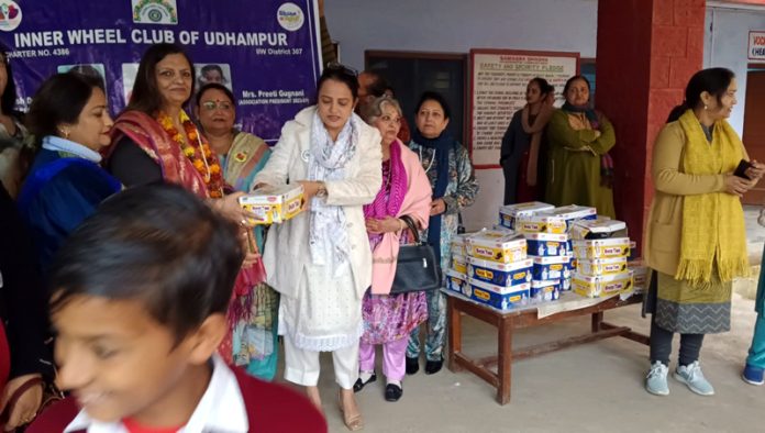 Members of Inner Wheel Club distributing uniform and shoes to children at a School in Udhampur on Friday.