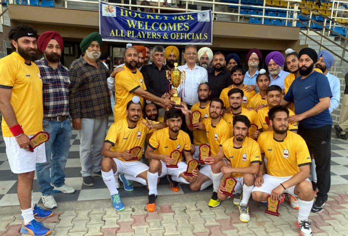 Winning hockey team posing with trophy at Jammu.