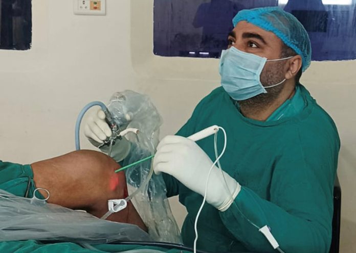 A doctor performing a procedure on a patient at GHRC Kathua.