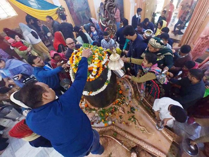 Devotees offer water and flowers on Shivlingam at Ranbireshwar Temple in Jammu on Maha Shivratri. -Excelsior/Rakesh