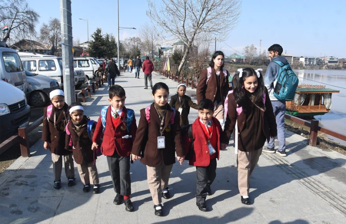 Students going to school after three months winter break in Srinagar on Monday. — Excelsior / Shakeel
