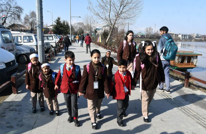 Students going to school after three months winter break in Srinagar on Monday.— Excelsior / Shakeel