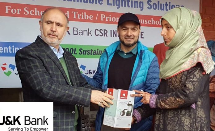 Beneficiary receiving solar lanterns from J&K Bank GM in Ganderbal on Friday.