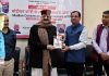Devender Singh Rana being presented a copy of 'Modi Consensus' at a function on Tuesday.