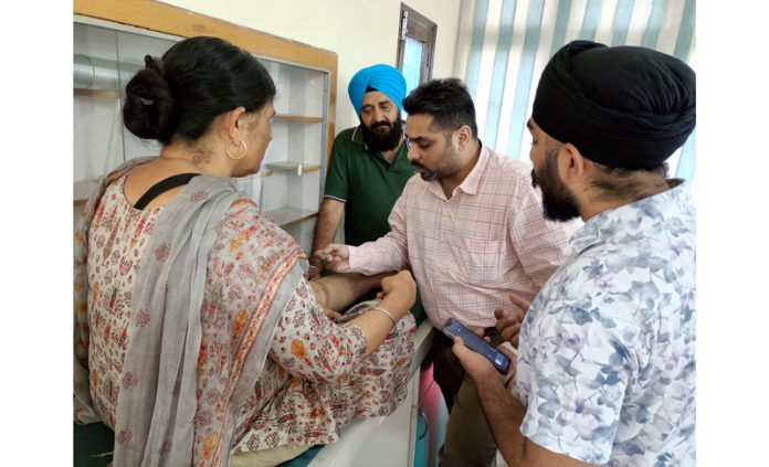 A doctor examining a patient during a medical camp at Jammu on Tuesday.