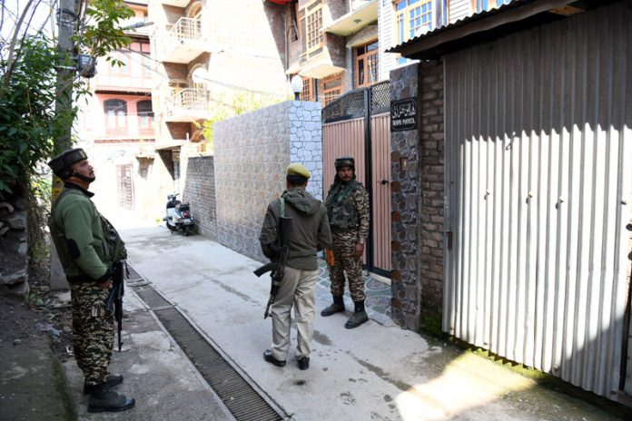 Security personnel stand guard during NIA raids at Shalla Kadal in Habba Kadal area of Srinagar. -Excelsior/Shakeel