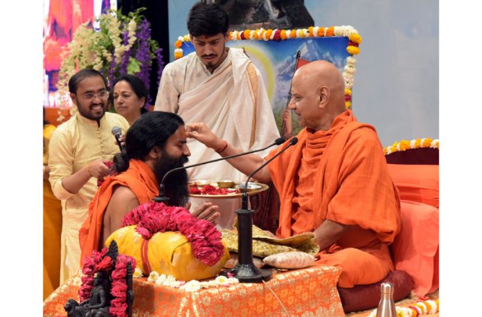 Swami Govind Dev Giri Ji Maharaj applying Tilak to Baba Ramdev on 4th day of Chhatrapati Shivaji Maharaj katha in Haridwar on Friday.
