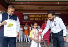 Nafisa Choudhary UKG student of Shiksha Niketan receiving certificate and gift hamper from school Principal.