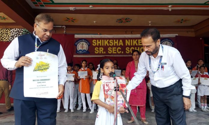 Nafisa Choudhary UKG student of Shiksha Niketan receiving certificate and gift hamper from school Principal.