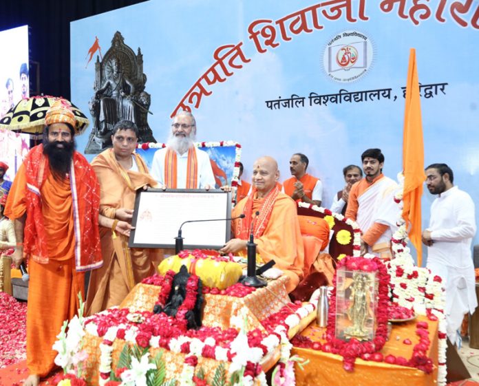 Swami Govind Dev Giri Ji felicitating Yoga Guru Baba Ramdev and Acharya Bal Krishna during a programme in Haridwar on Wednesday.