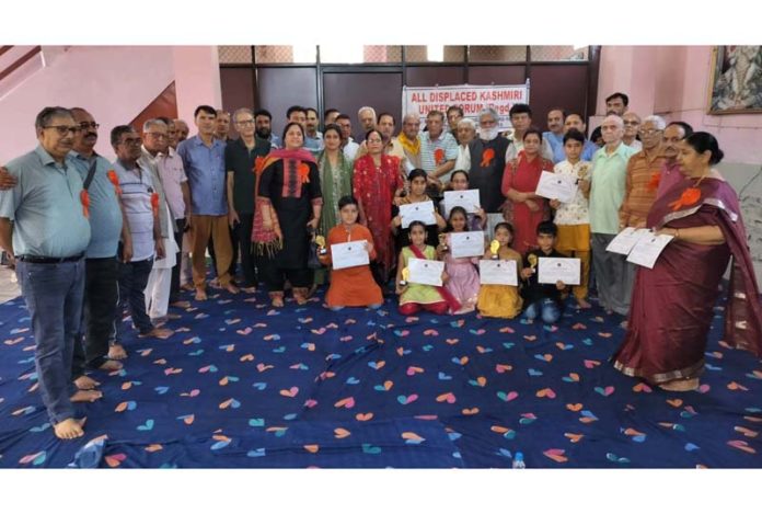 Children who received trophies and certificates during a socio-cultural programme posing with organisers of the function at Durga Nagar on Sunday.