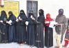 Women show their voters identity cards while waiting in a queue to cast their at a polling station, in Muzafarnagar, Uttar Pradesh on Friday. (UNI)