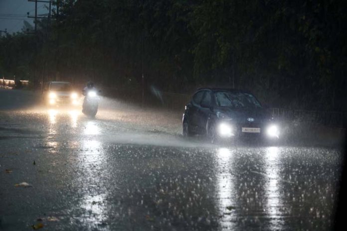 Vehicles move with head-lights on amid heavy rains in Jammu on Monday evening. -Excelsior/Rakesh