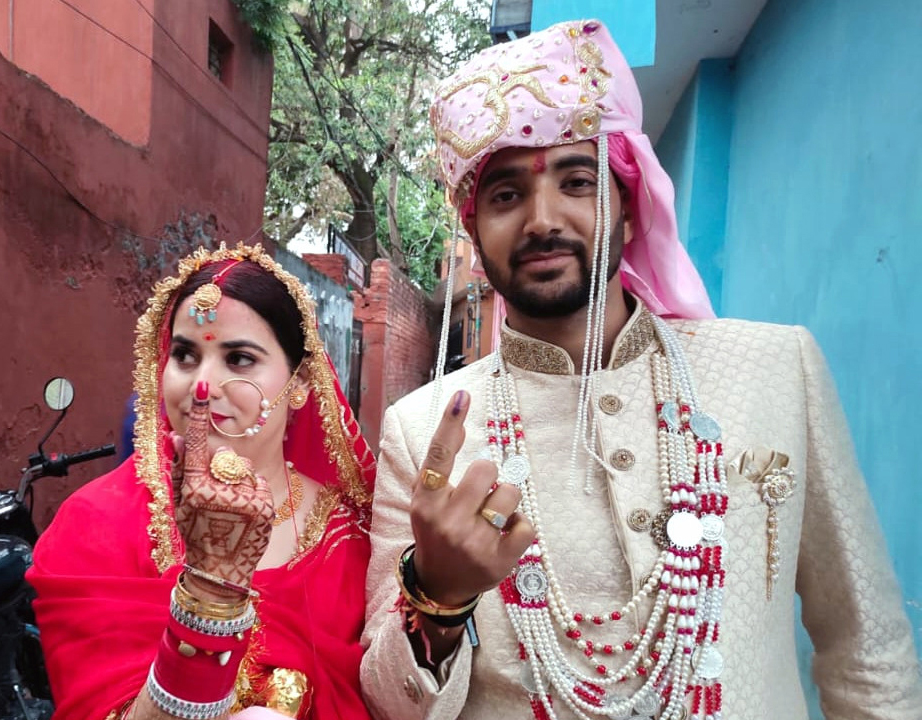 A newly-wed copule displayingtheir inked fingers after casting votes at a polling booth in Udhampur town.