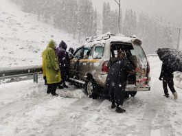 Stranded tourists being rescued by locals at Chandanwari in Anantnag district on Monday.