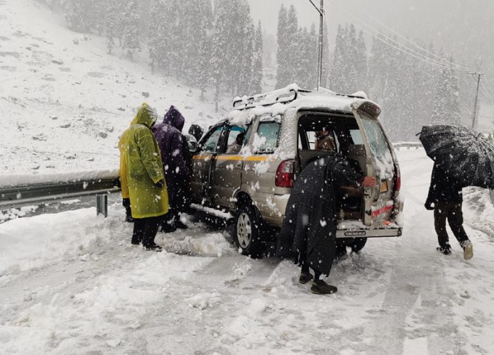 Stranded tourists being rescued by locals at Chandanwari in Anantnag district on Monday.