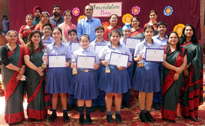 Students displaying certificates while posing with teaching faculty.