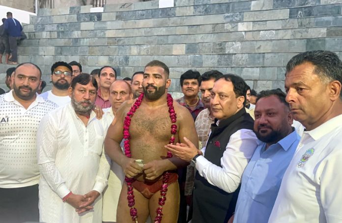 Chief Guest Sohail Kazmi along with other dignitaries posing with wrestler.
