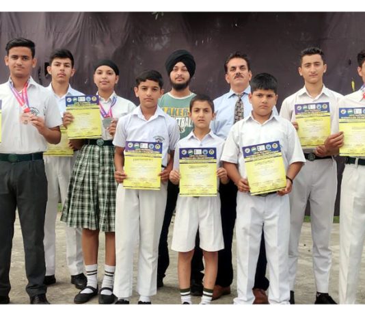 Martial art athletes of Delhi Public School Kathua posing along with medals and certificates.