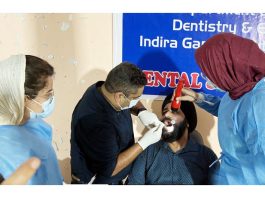 A doctor from IGGDC&H examining a patient during a dental camp in Jammu.