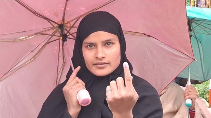 A female voter takes umbrella cover after casting her vote in Banihal. -Excelsior/Shubam Anthalc