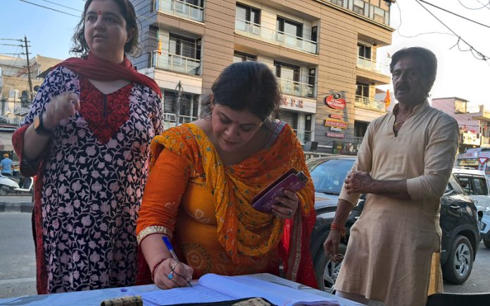 A lady puting her signature during a campaign by DADAA for the demand of Duggar Channel.
