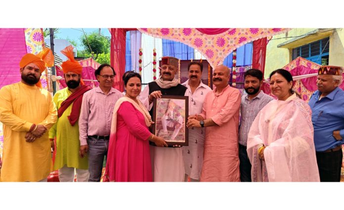 Sr BJP leader Devender Singh Rana being presented a portrait of Mian Deedo.