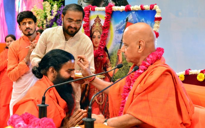 Swami Govind Dev Ji applying tilak to Yog Guru Ramdev on the 8th day of saga of Shiva Ji Maharaj in Haridwar on Tuesday.