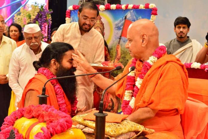Swami Govind Dev Giri Ji Maharaj applying tilak to Baba Ram Dev during a function organised at Haridwar on Sunday.