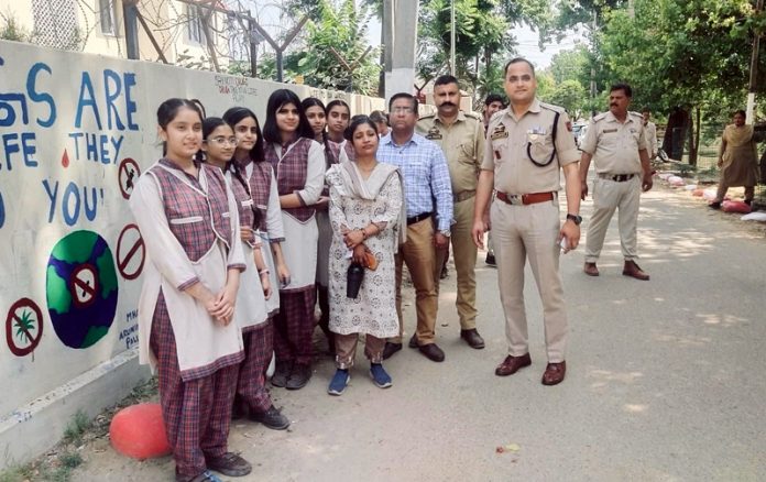 School students and police officers during a wall painting competition organised at Domana area of Jammu District on Friday.