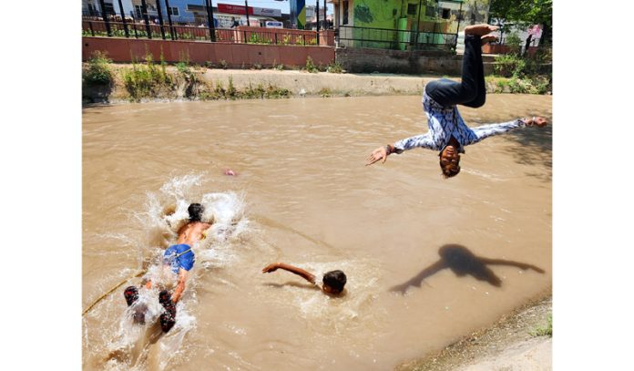 Amid scorching heat, children bathing in Ranbir Canal in Jammu on Tuesday. -Excelsior/Rakesh