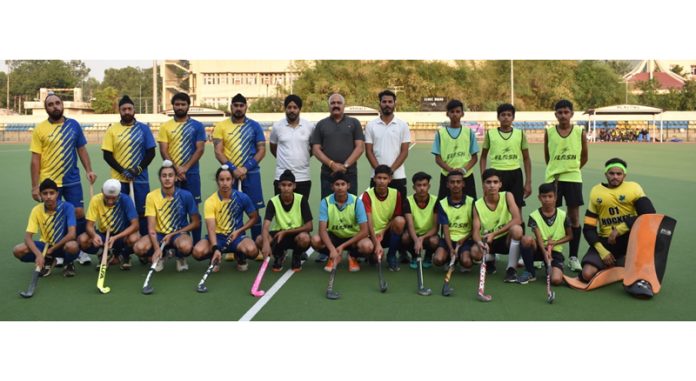 Players of a team posing with guests before start of their match at KK Hakku Stadium, Jammu.