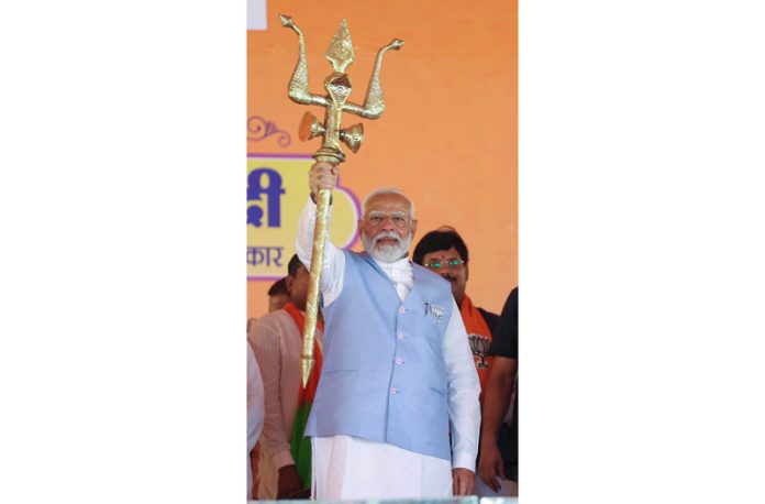 Prime Minister Narendra Modi holds a trident at a public meeting in Uttar Pradesh on Friday. (UNI)