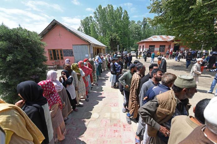 People wait in long queues to cast their votes in Shalabugh area at Srinagar on Monday. -Excelsior/Shakeel