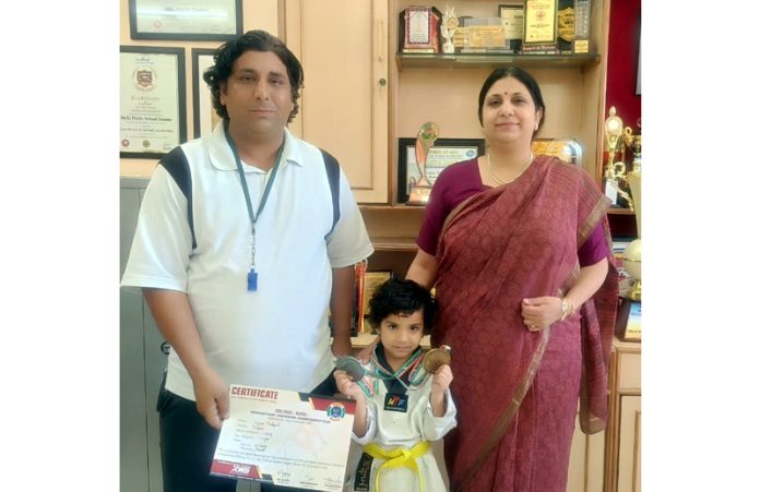 Principal DPS Jammu Ruchi Chabra and a teacher posing with a student who won medals in International Taekwondo Championship.