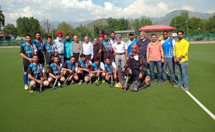 Guests and match officials posing with a Hockey team at Astro Turf Hockey Playfield, Polo Ground, Srinagar.