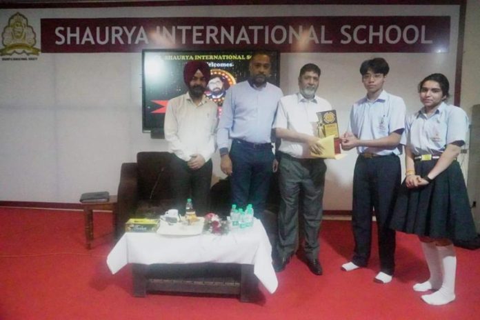 Senior Journalist Arun Joshi presenting award to students during a programme on Saturday.