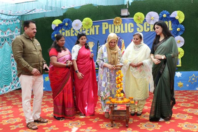 Chief Guest Seerat Baji lighting lamp during a programme. 