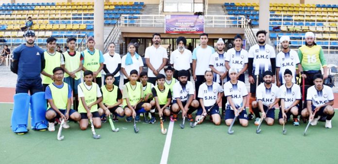 Players of a team posing with guests before start of their match at KK Hakku Stadium, Jammu.