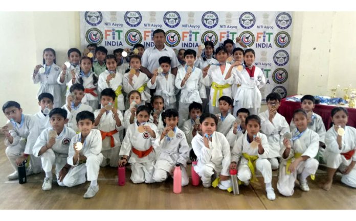 Players displaying their medals while posing for a group photograph.