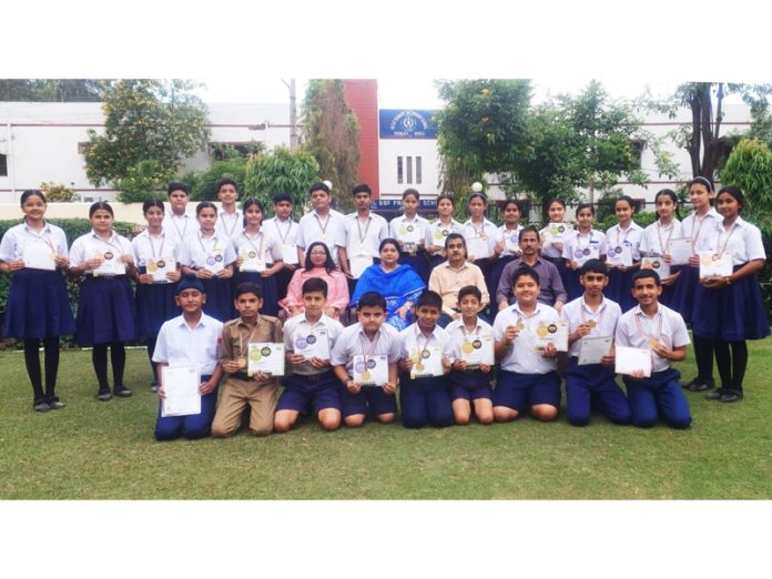 Students of BSF school posing with certificates and Dr S.K Shukla, Principal BSF School at Jammu.