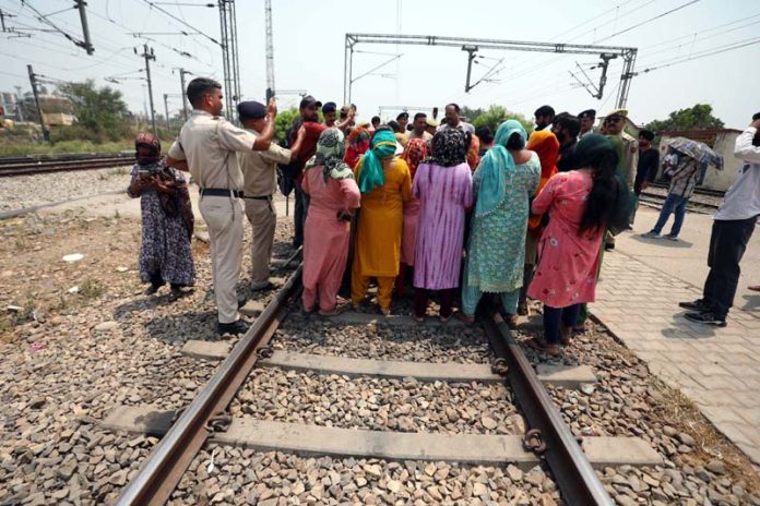 Family members of Railway staff protesting on rail-track against acute shortage of water to Railway Colony, near Jammu Station on Thursday. -Excelsior/Rakesh