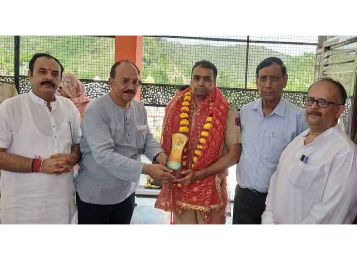 Shatrughan Jamwal felicitating SHO Purmandal during medical camp organised on Monday.